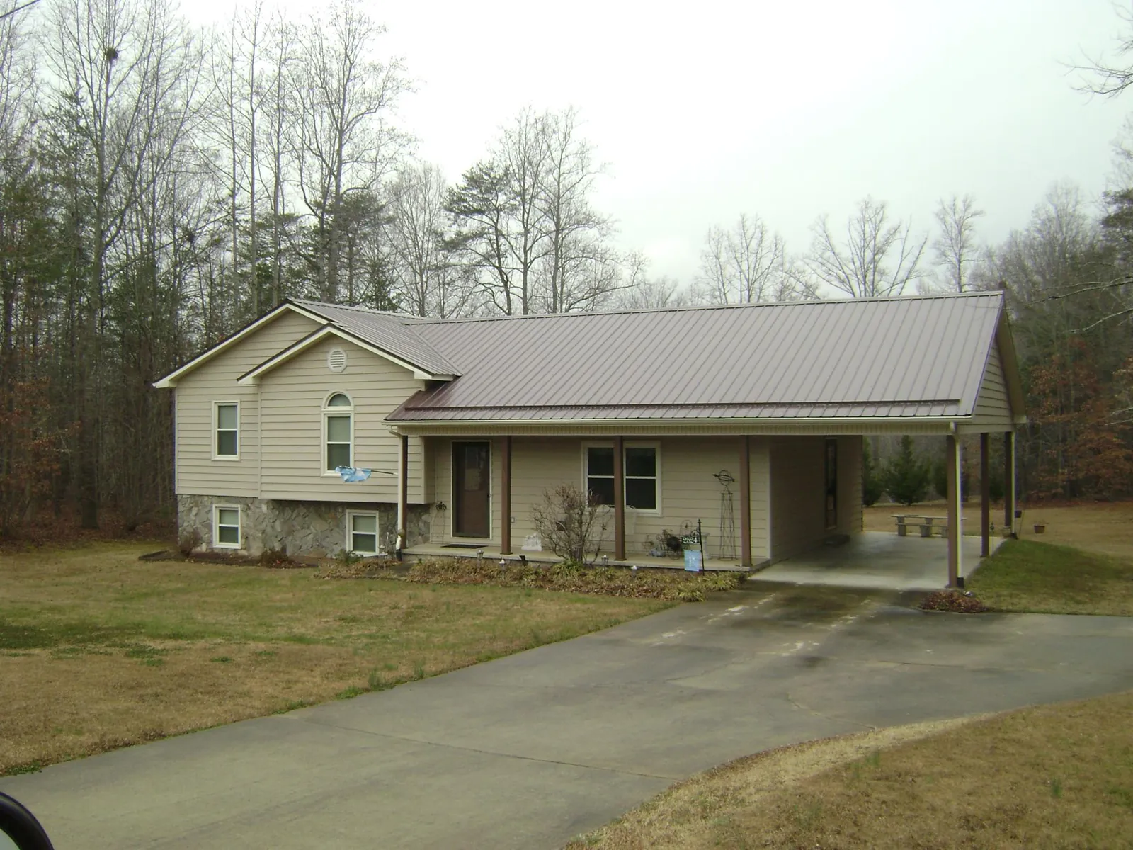 Brown metal roof on a tan split level home with an attached carport in Kings Bay